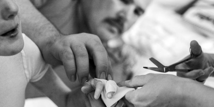 This photo is of a young girl getting her hand bandaged.