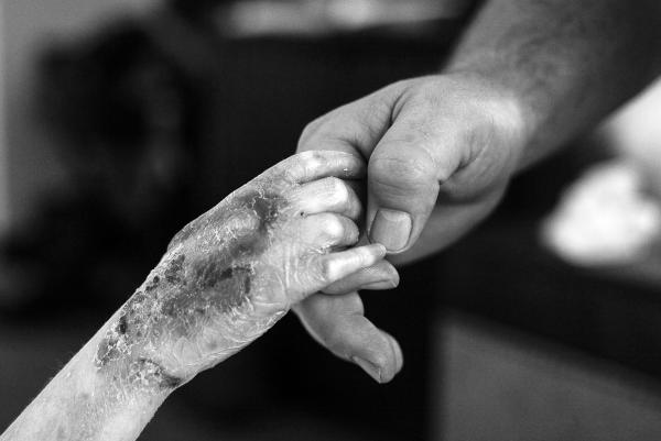 This photo is of an adult hand holding child's hand.