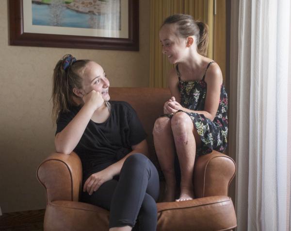 This is a photo of two girls on a couch laughing.