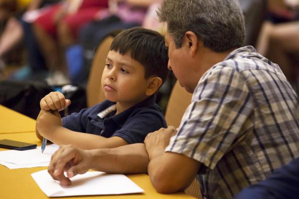 Adult and child listening to presentation.